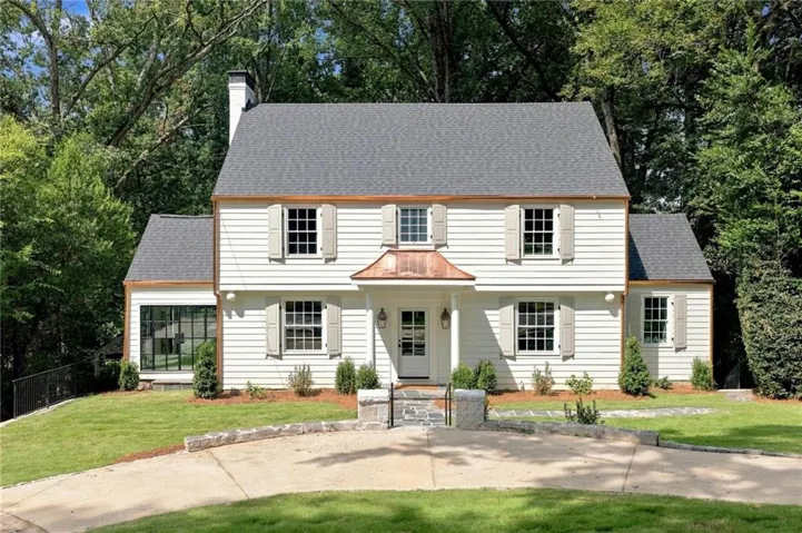 White siding exterior with a dark grey shingle roof and copper gutters
