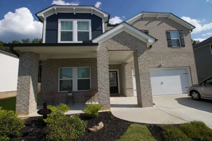 Brick and siding exterior with a covered front porch and an attached garage