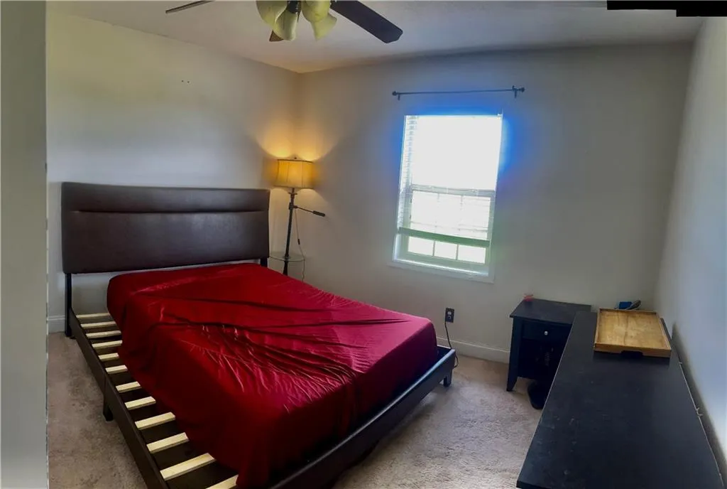 Carpeted bedroom with baseboards and ceiling fan