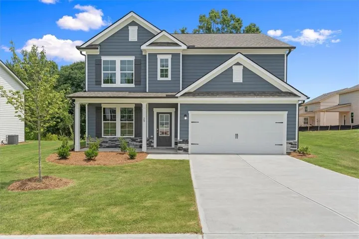 Two-story home with a blue siding exterior, white trim accents, and a covered front porch featuring stone detailing