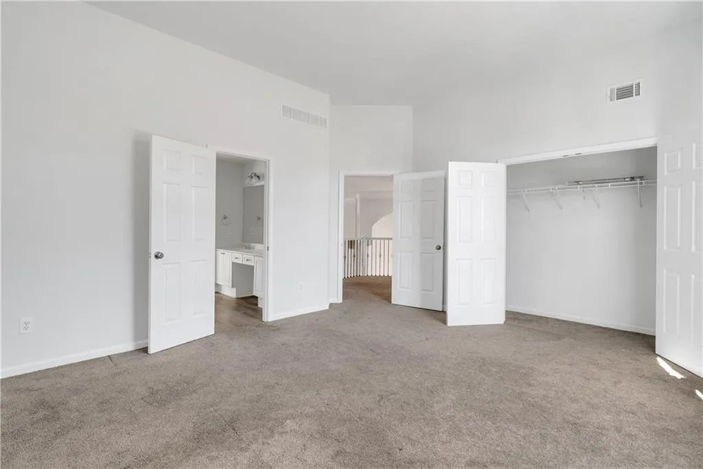 Unfurnished bedroom with carpet, a closet, visible vents, and baseboards