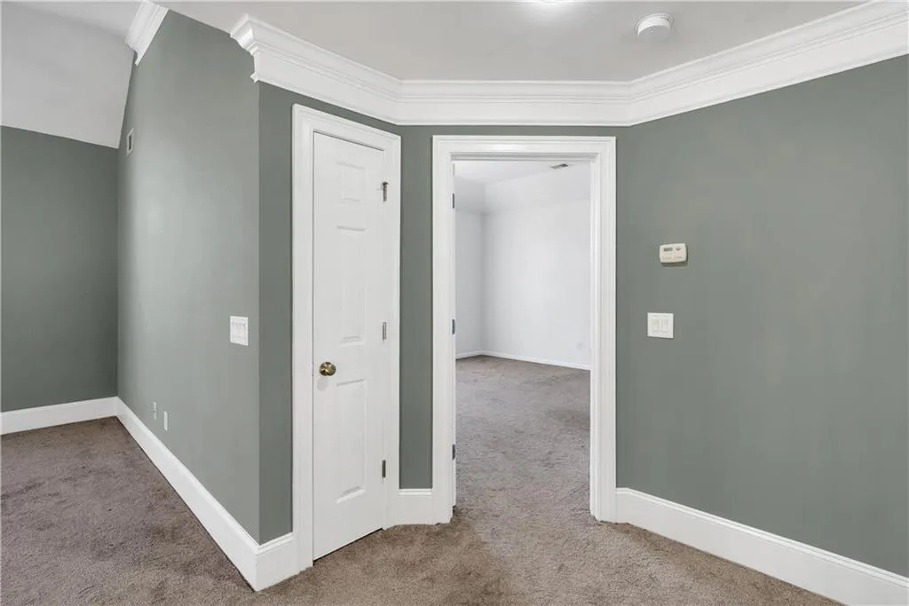 Hall featuring carpet, crown molding, and baseboards