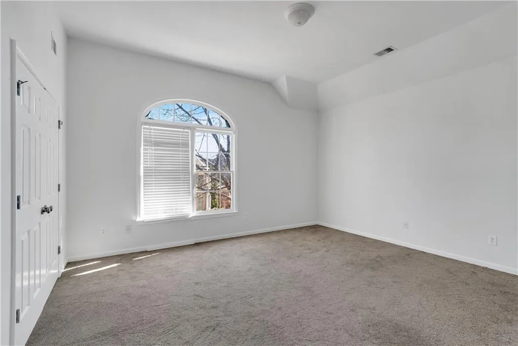 Carpeted spare room featuring visible vents and baseboards