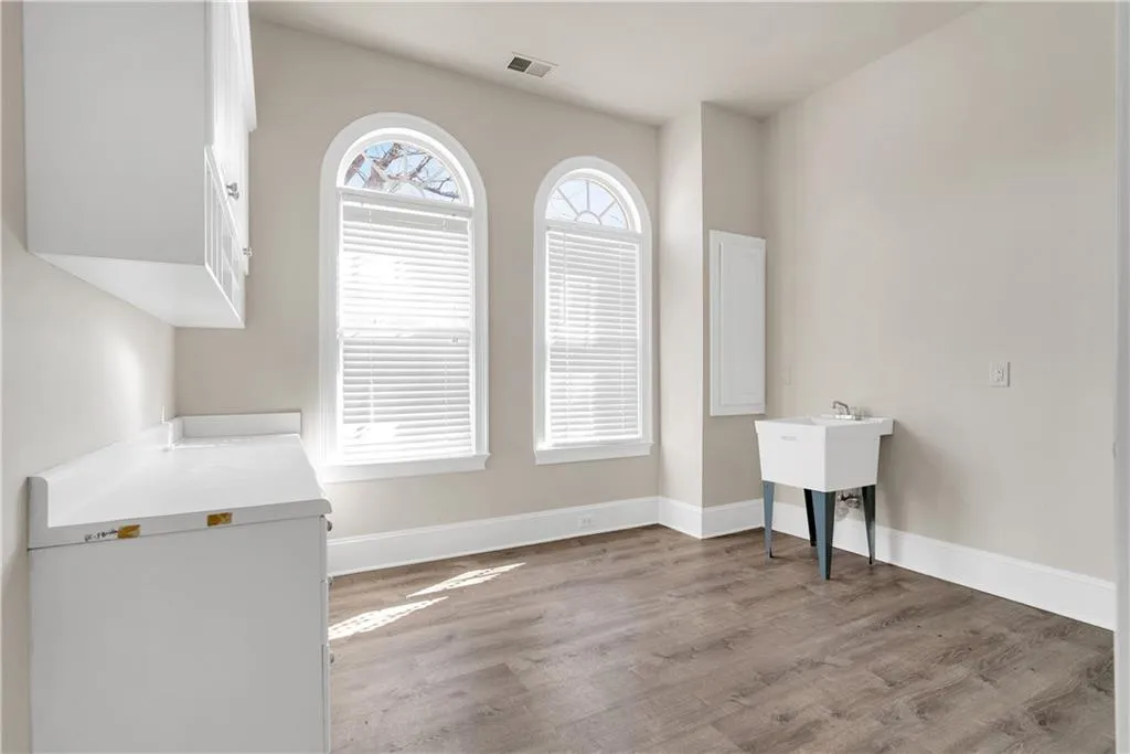 Unfurnished dining area featuring light wood-style flooring, visible vents, and baseboards