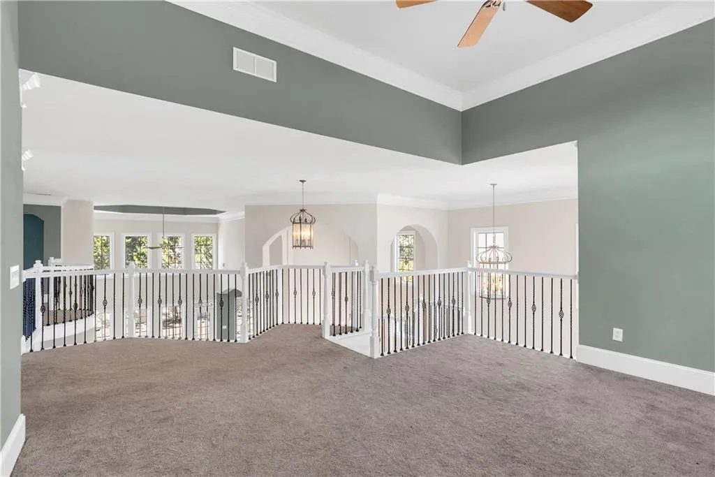 Spare room featuring carpet floors, visible vents, and a wealth of natural light