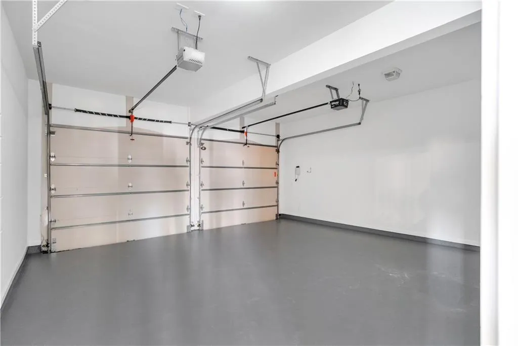 Garage with baseboards and a garage door opener