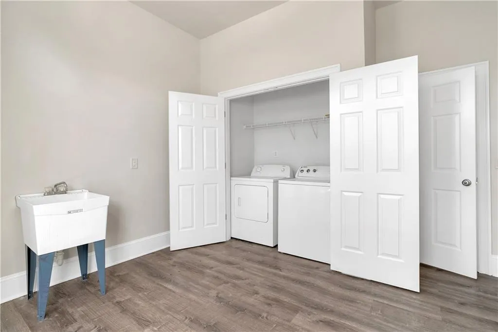 Clothes washing area featuring laundry area, separate washer and dryer, dark wood finished floors, and baseboards