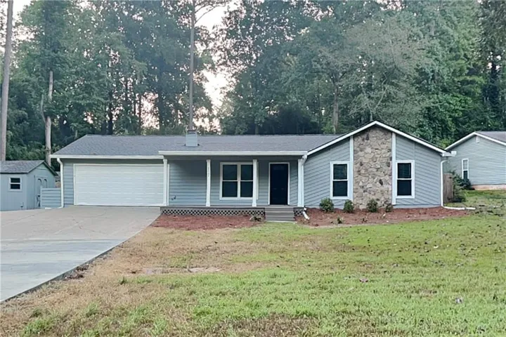 Single-story residence featuring light gray siding, stone accents, and a covered front porch
