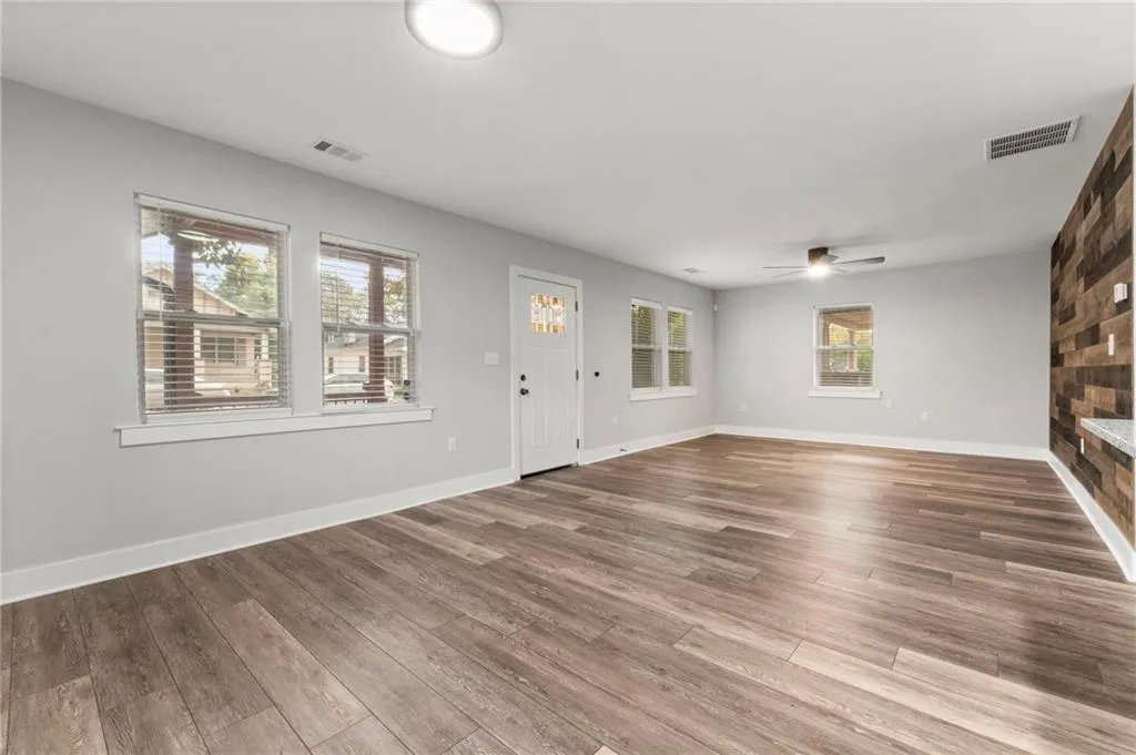 Unfurnished living room featuring wood finished floors and ceiling fan
