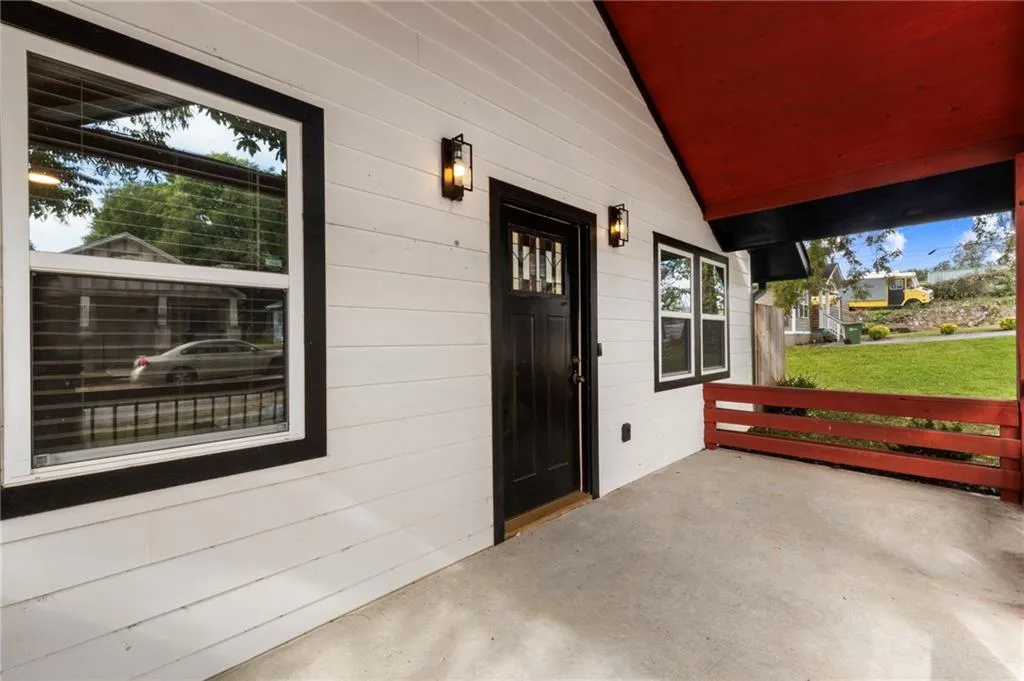 Property entrance with a patio area and a lawn