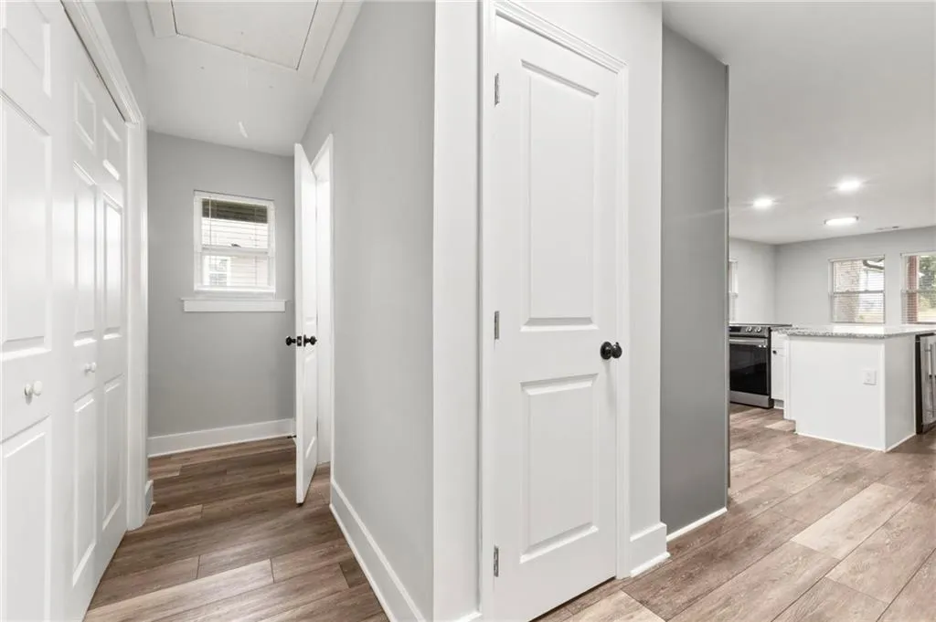 Hall featuring attic access and light wood finished floors