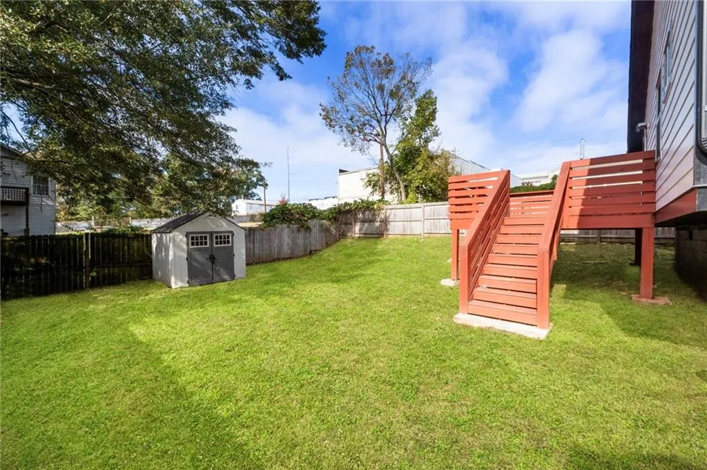 Fenced backyard featuring a storage unit