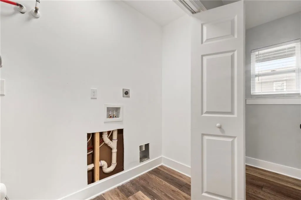 Washroom featuring dark wood-style floors, washer hookup, and hookup for an electric dryer