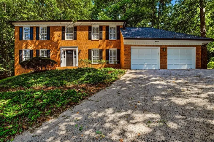 Brick exterior with a dark shingle roof