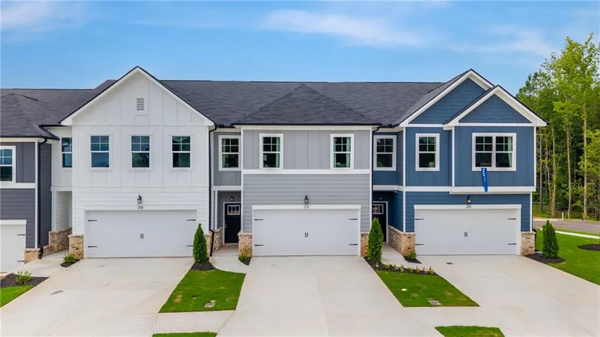 Modern townhome exteriors with varied siding, attached garages, and paved driveways