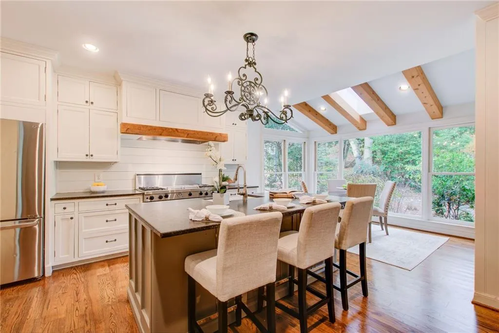 Take a look at this wonderful eat in kitchen with beautiful countertops, an island and space for everyone.