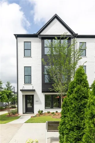 Modern townhome exterior with white brick facade and black trim accents
