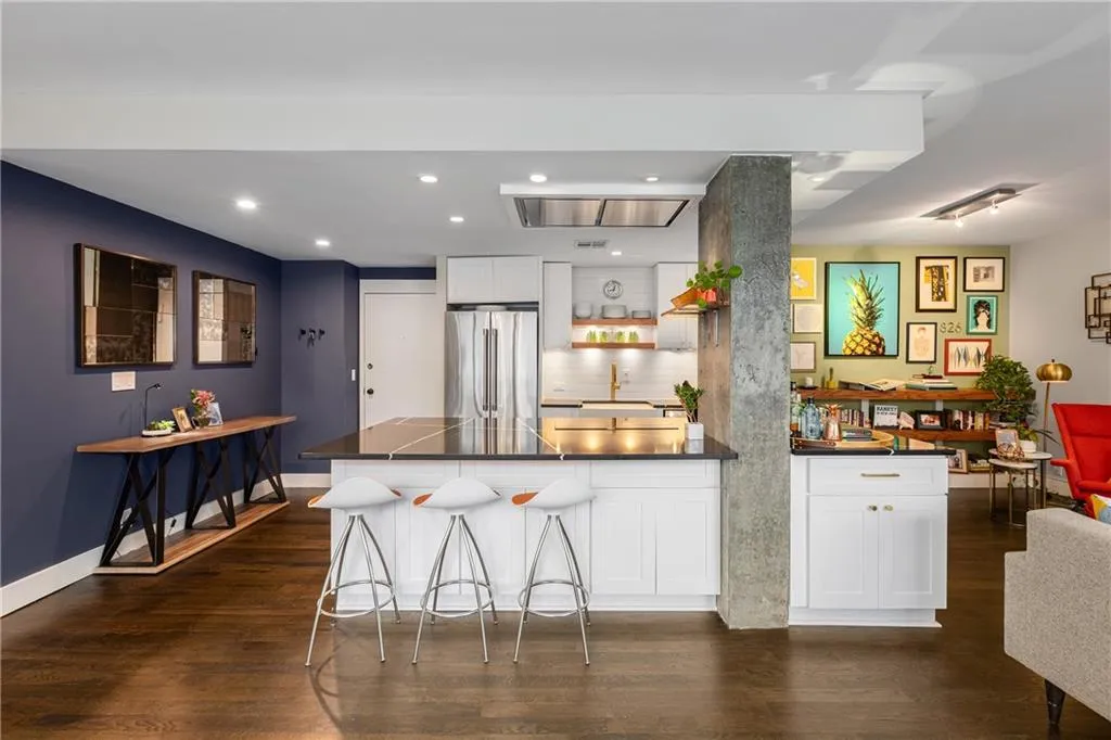 Kitchen with freestanding refrigerator, dark countertops, a peninsula, dark wood finished floors, and recessed lighting