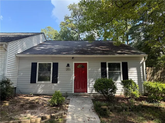 Light-colored siding exterior with a contrasting red entry door