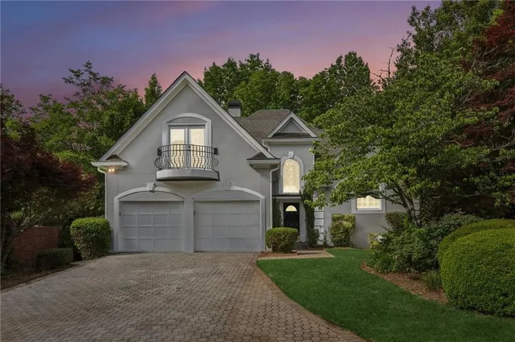 Stucco exterior featuring an arched entryway and gabled roofline