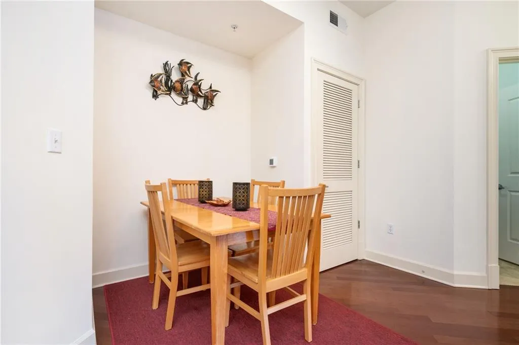 Dining space with visible vents, baseboards, and wood finished floors