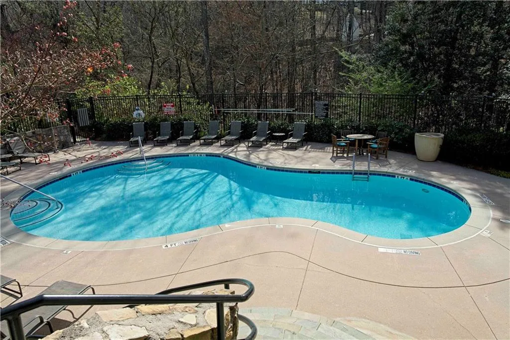 Community pool featuring a patio and fence