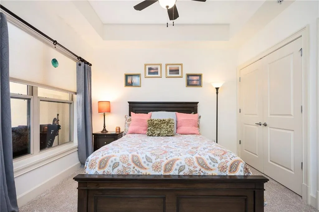 Carpeted bedroom featuring baseboards, a closet, and ceiling fan