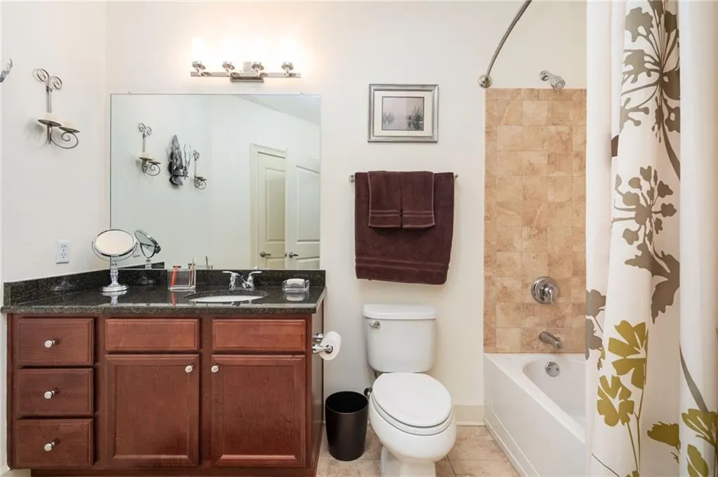 Full bath with tile patterned flooring, toilet, vanity, and shower / bath combo