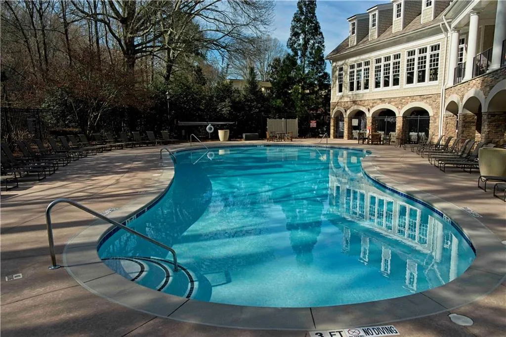Community pool featuring a patio and fence