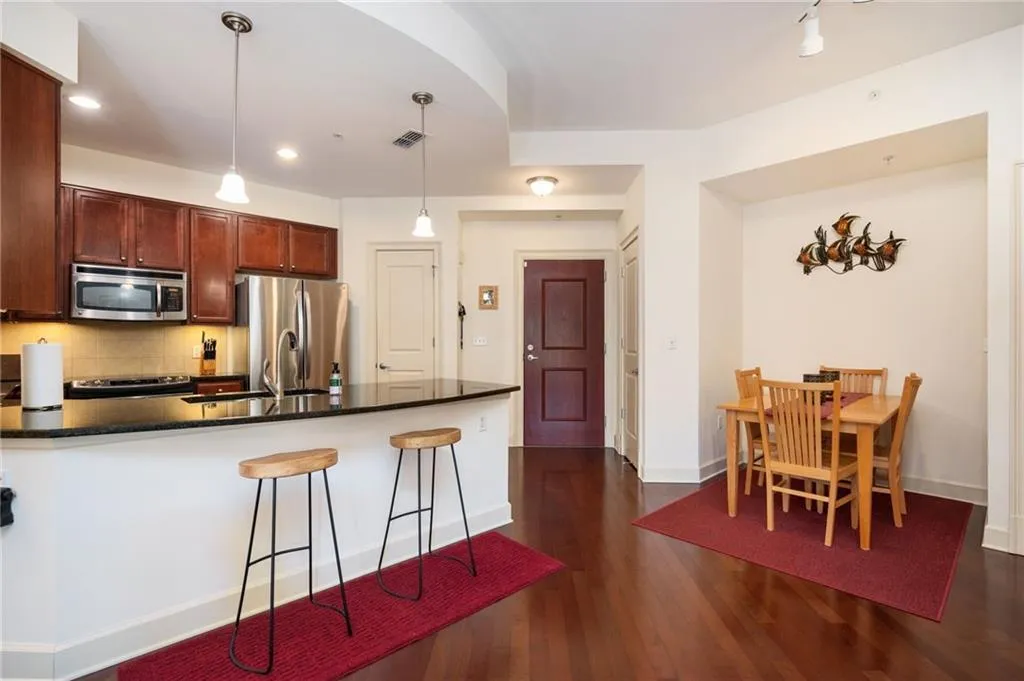 Kitchen with visible vents, backsplash, dark wood finished floors, stainless steel appliances, and a peninsula