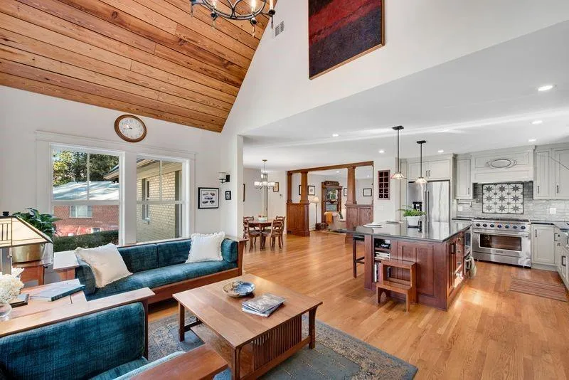 Living area with a chandelier, light wood finished floors, and a vaulted wooden ceiling