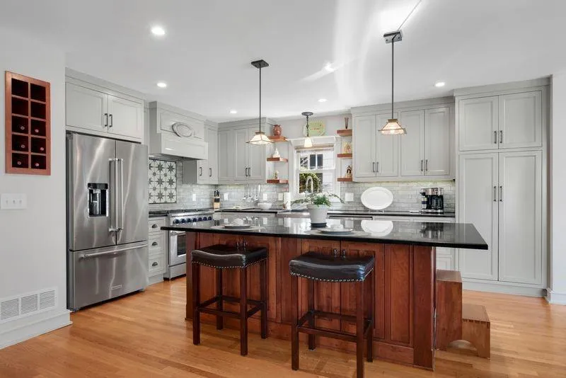 Kitchen featuring open shelves, premium appliances, decorative light fixtures, a kitchen bar, and a center island