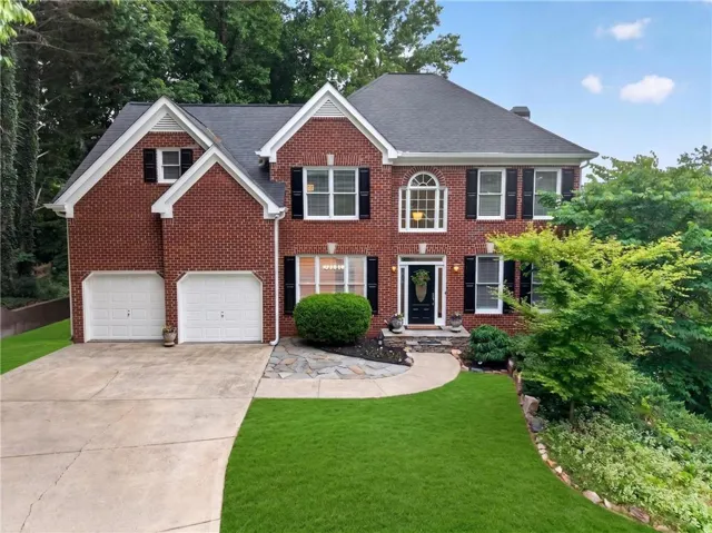 Traditional brick exterior featuring a multi-gabled roofline and black shutters