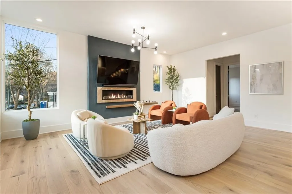 Living area with wood finished floors, baseboards, recessed lighting, a chandelier, and a large fireplace