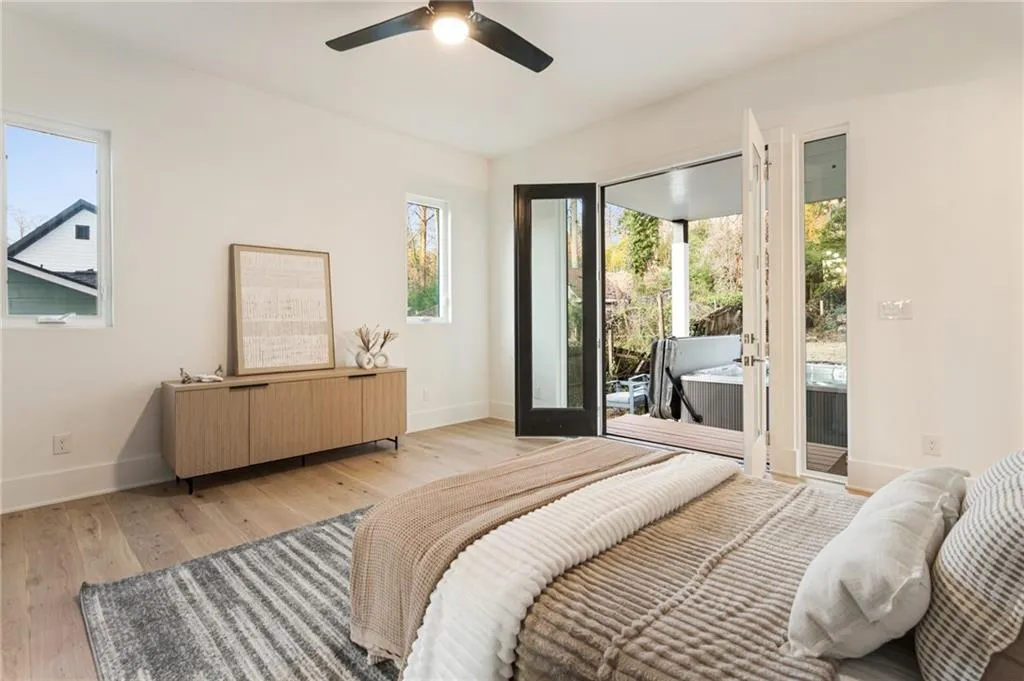 Bedroom featuring access to exterior, baseboards, light wood finished floors, and a ceiling fan