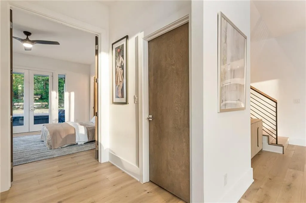 Hallway featuring light wood-type flooring, stairs, french doors, and baseboards