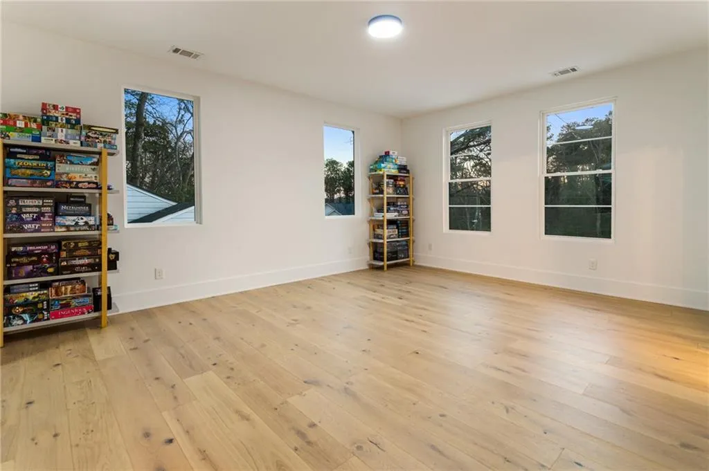 Unfurnished room featuring plenty of natural light, light wood-type flooring, and baseboards