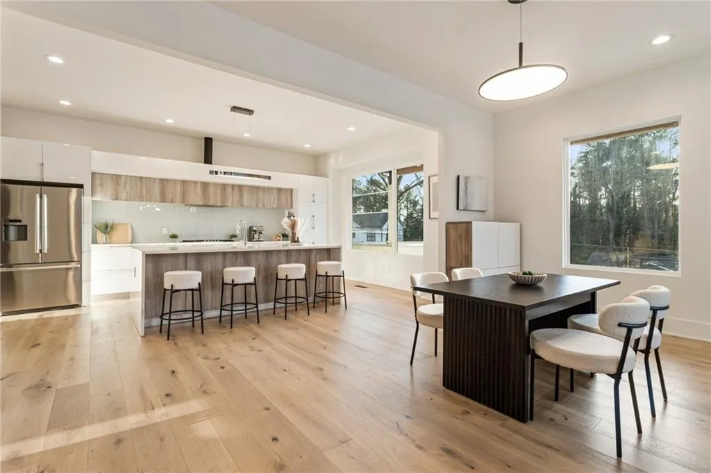 Dining space featuring light wood finished floors, healthy amount of natural light, and recessed lighting