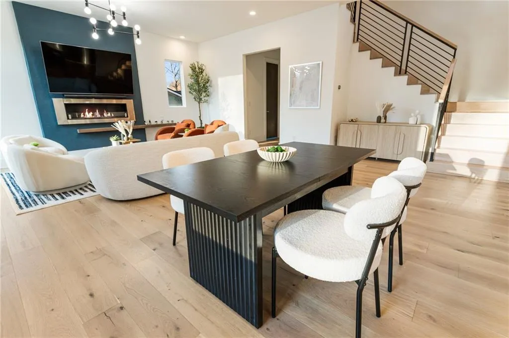 Dining area with light wood-style flooring, stairway, a fireplace, and recessed lighting
