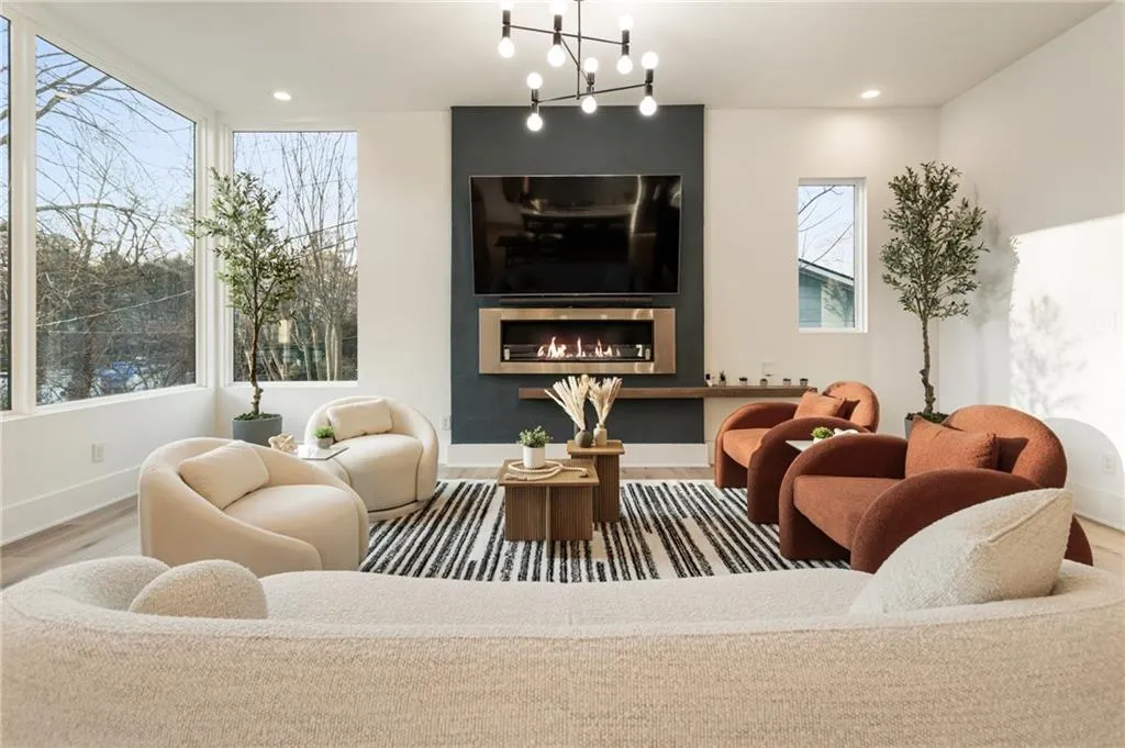 Living area featuring wood finished floors, baseboards, healthy amount of natural light, a chandelier, and recessed lighting