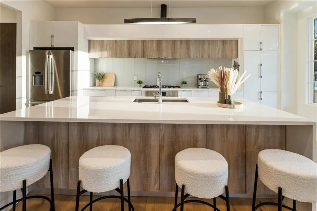 Kitchen featuring stainless steel refrigerator with ice dispenser, backsplash, modern cabinets, and light countertops