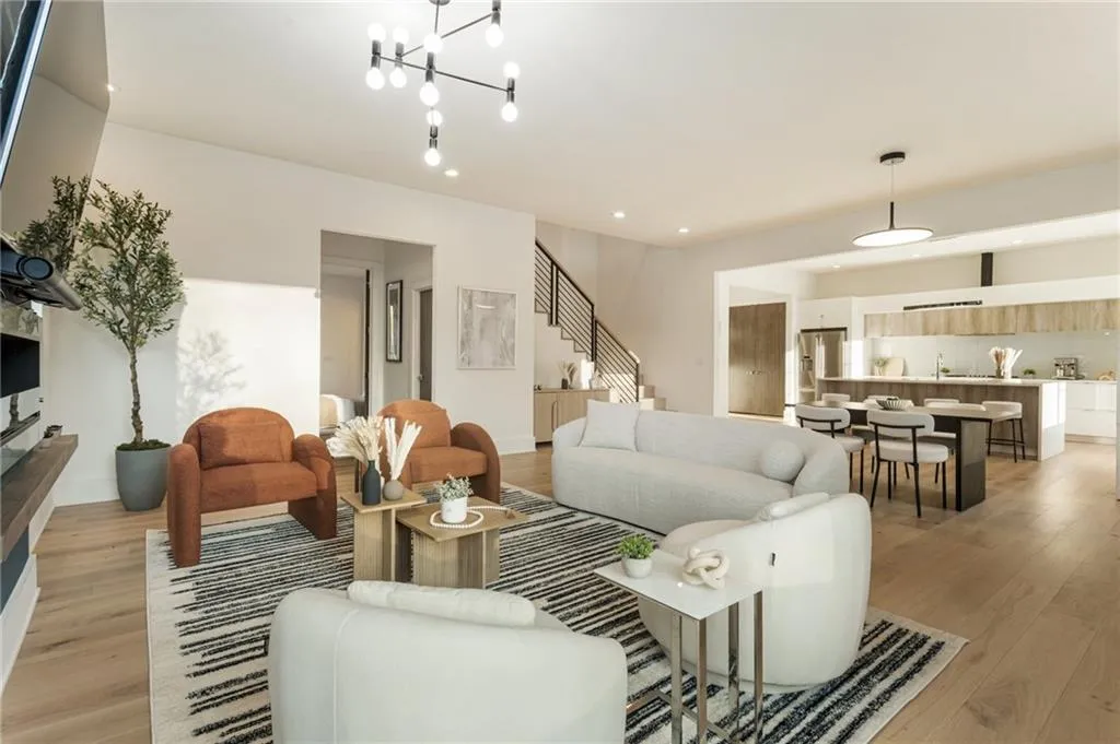 Living room featuring light wood-type flooring, stairway, baseboards, recessed lighting, and a chandelier
