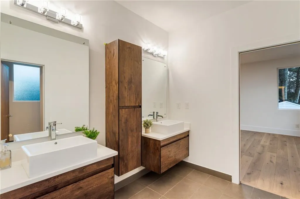 Bathroom with vanity, baseboards, and tile patterned floors
