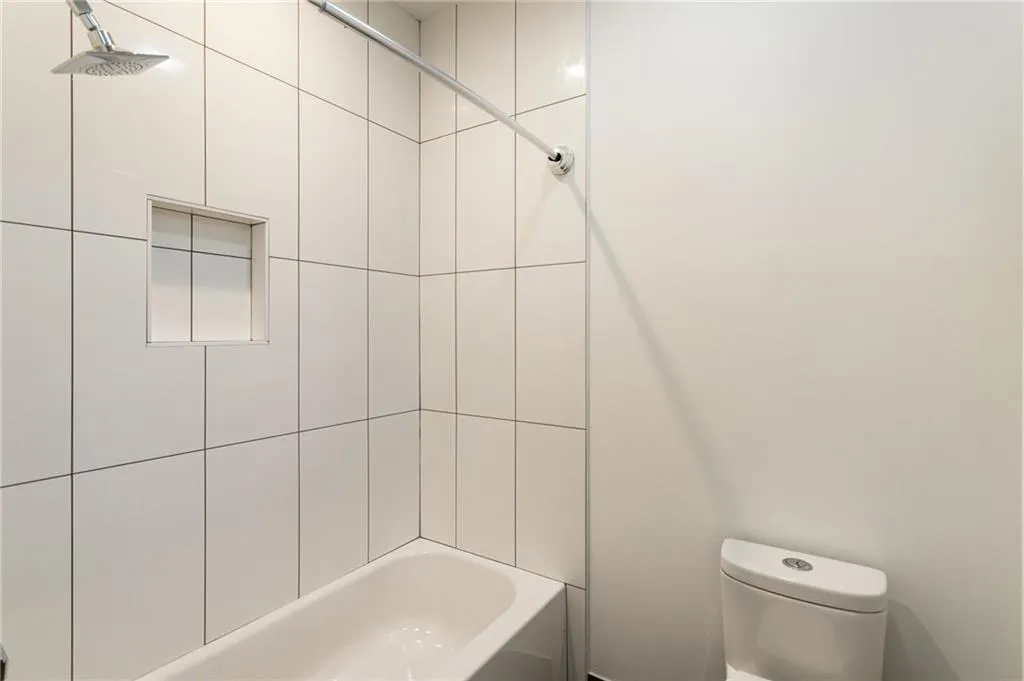 Full bathroom featuring toilet and washtub / shower combination