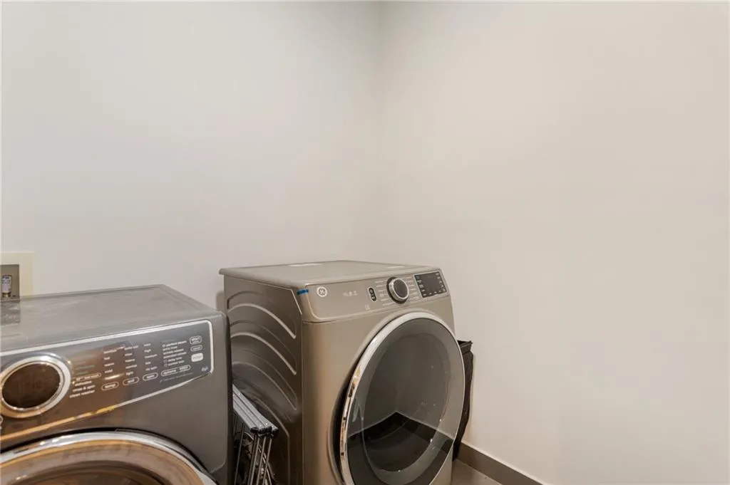 Washroom with washing machine and clothes dryer and baseboards