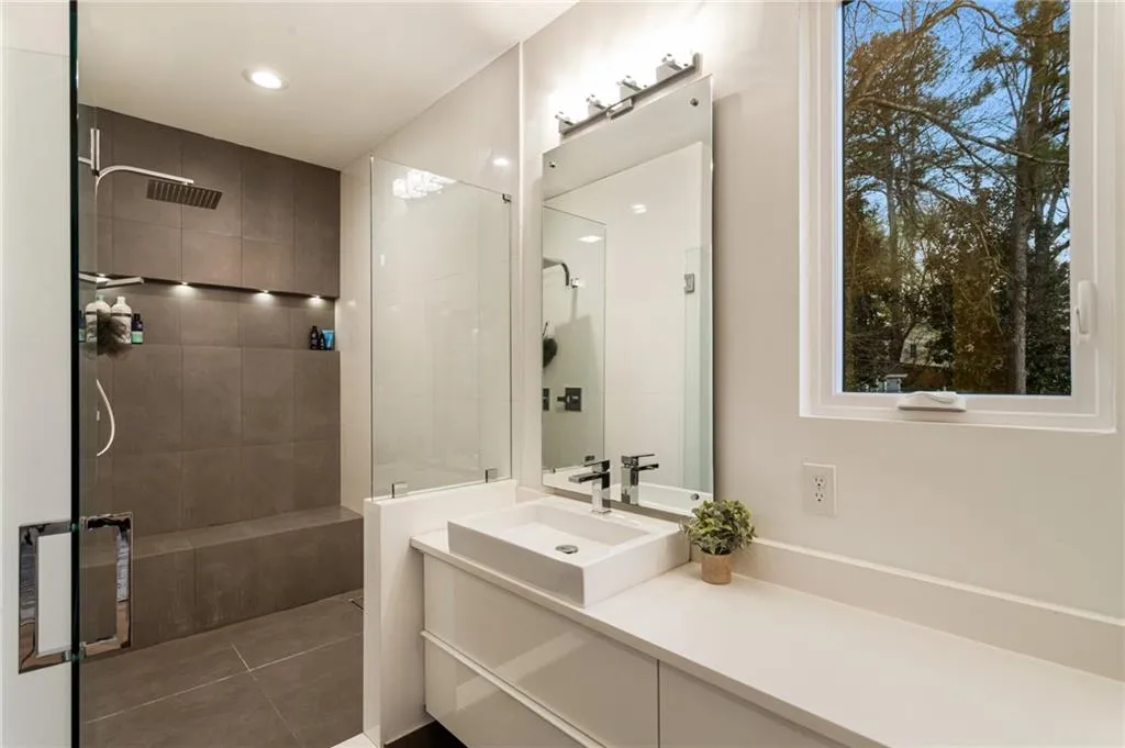 Full bath featuring a walk in shower, vanity, tile patterned floors, healthy amount of natural light, and recessed lighting