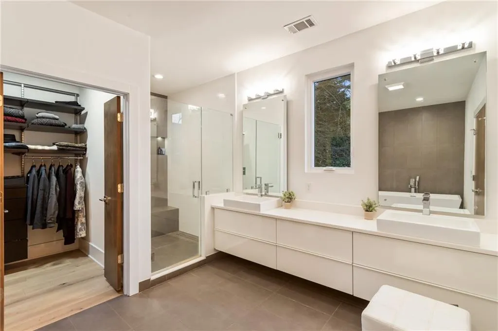 Bathroom featuring a shower stall, vanity, a spacious closet, and tile patterned flooring