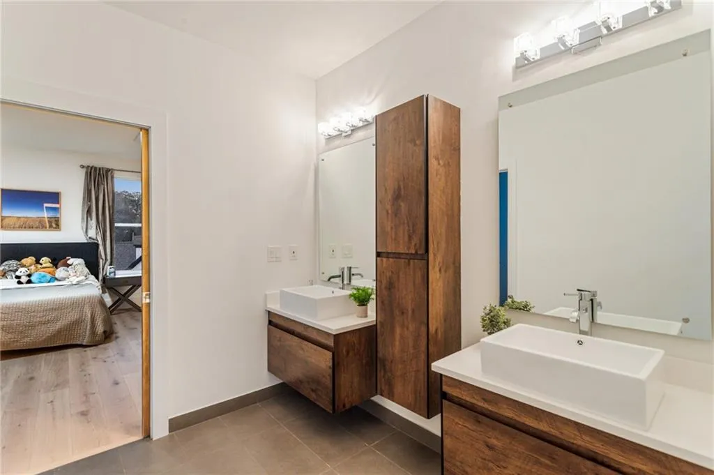 Ensuite bathroom featuring vanity, tile patterned flooring, and baseboards