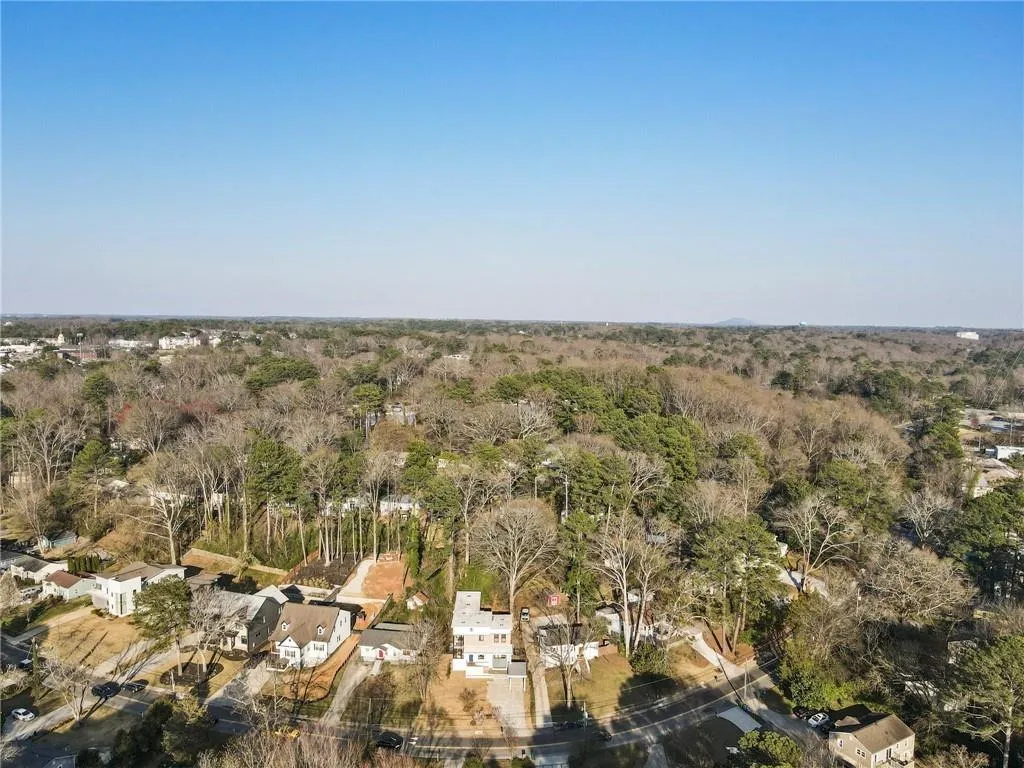 Aerial overview of property's location featuring a forest and nearby suburban area