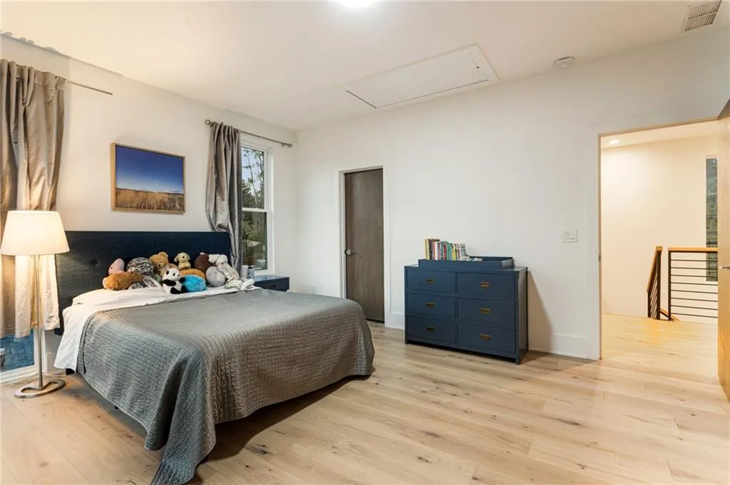 Bedroom featuring attic access and light wood-style floors